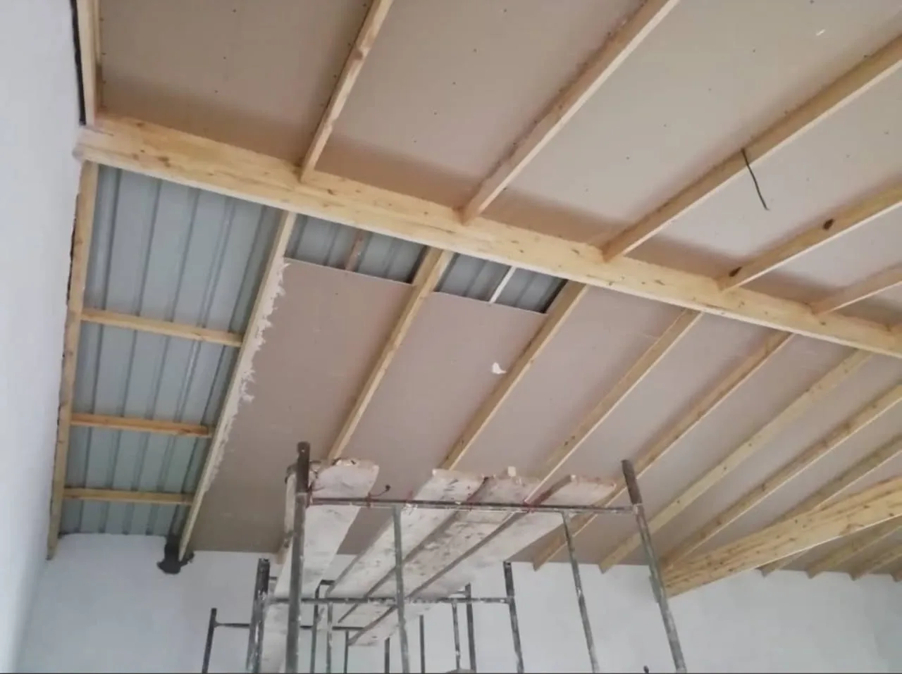 Ceiling boards being installed onto a timber frame