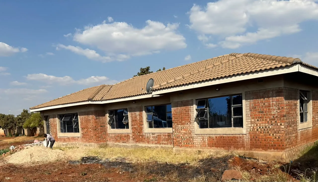 Long brick residential building with tiled roof and installed windows