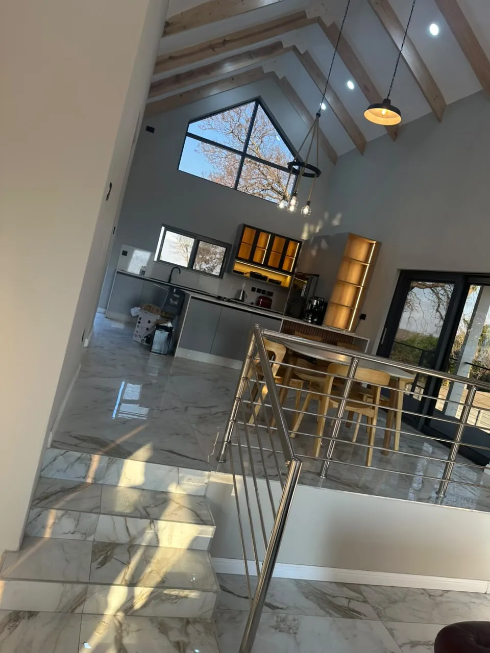 Finished open-plan interior with exposed beams, kitchen and tiled floor