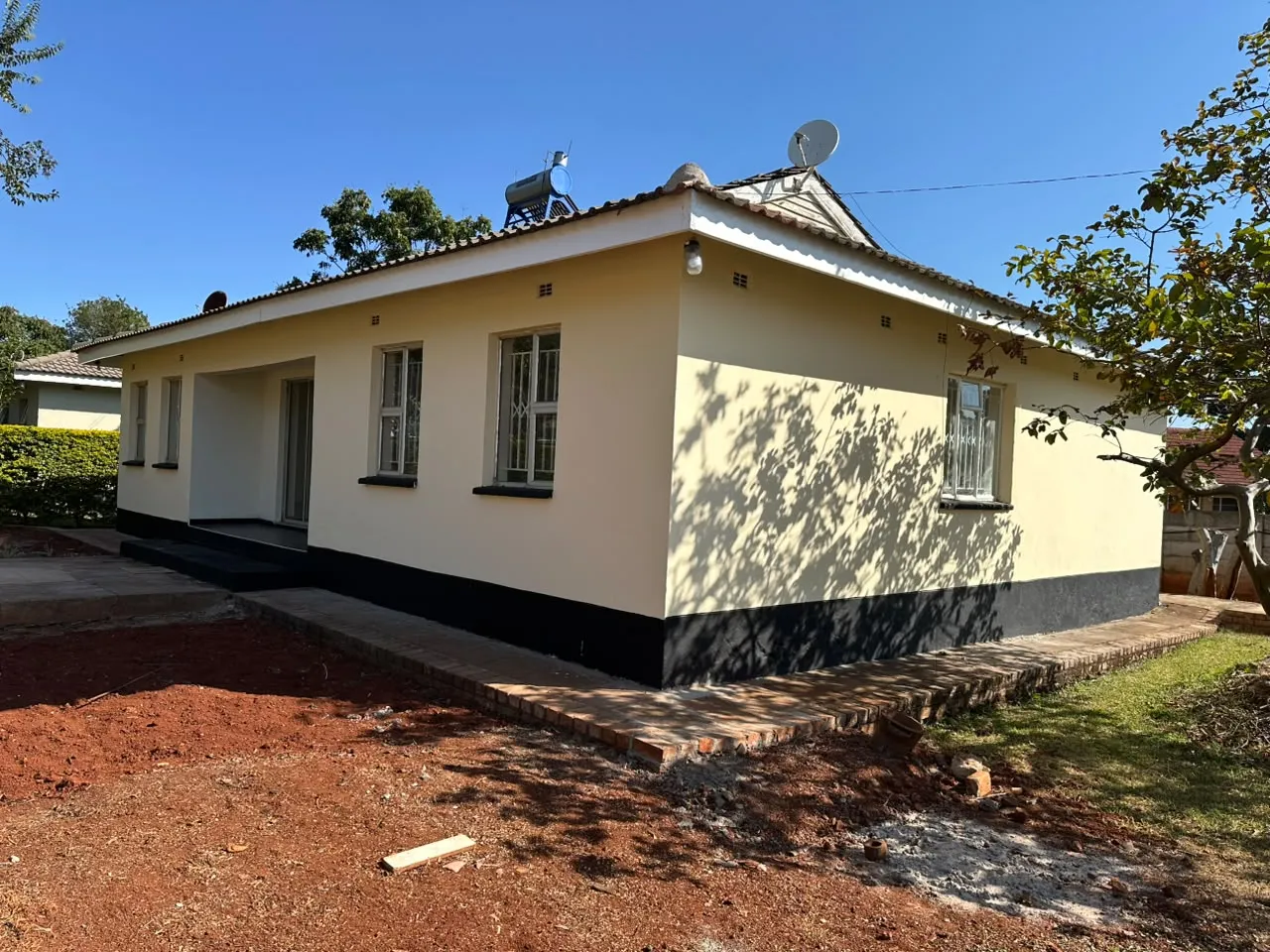 Freshly painted exterior with cream walls and dark lower trim
