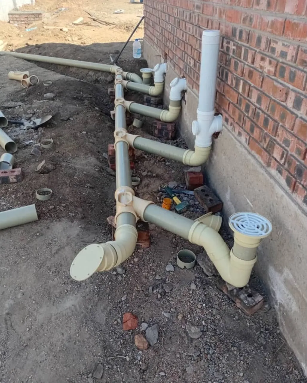 Drainage pipe network installed beside a brick building