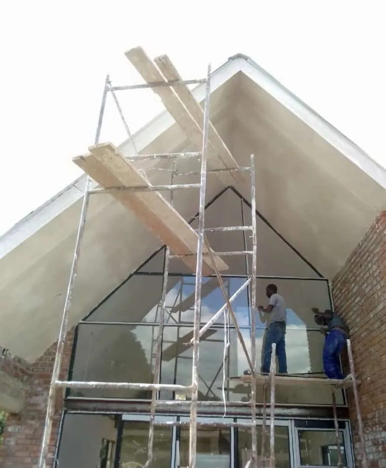 Workers installing a large glazed section during a building renovation