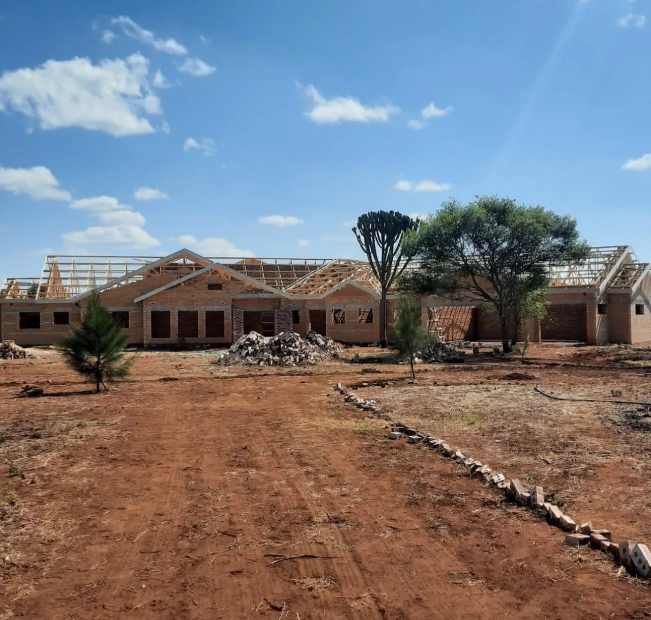 Wide residential building with timber roof trusses being installed