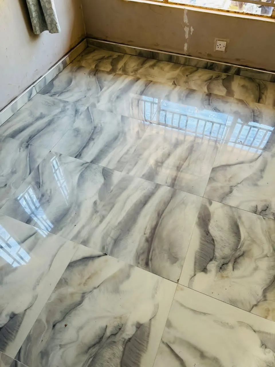 Room finished with reflective marble-effect floor tiles